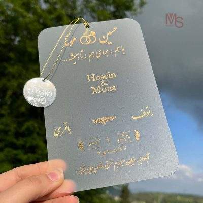 کارت عروسی مدل S386 | طراحی لوکس و خاص برای روزی بی‌نظیرکارت عروسی یکی از مهم‌ترین اجزای هر مراسم عروسی است که نخستین تصویری که از جشن شما در ذهن مهمانانتان نقش می‌بندد را ترسیم می‌کند. به همین دلیل، انتخاب کارت عروسی مناسب با طراحی زیبا و منحصر به فرد می‌تواند شروعی خاص و خاطره‌انگیز برای جشن شما باشد. کارت عروسی مدل S386 از منش استور با ویژگی‌هایی همچون پاکت از جنس مقوا، لایی کارت از جنس طلق، چاپ طلاکوب، برش خاص، و طراحی لوکس و خاص، یک انتخاب ایده‌آل برای کسانی است که به دنبال کارت عروسی‌ای منحصر به فرد، شیک و با کیفیت هستند.