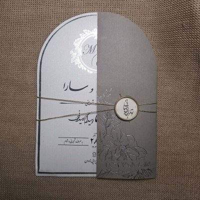 کارت عروسی گنبدی مدل IL455 با رنگ طوسی، اکسسوری‌های نخ، حلقه و لیبل "جان و جهانی" طراحی شده است. چاپ طلاکوب، طراحی خاص و آماده‌سازی ۵ روزه دارد. مونتاژ با مشتری است.