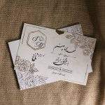 کارت عروسی مدل IL1167 با طراحی مینیمال و برش چند ضلعی روی پاکت، جلوه‌ای متفاوت و مدرن دارد. مقوای خارجی با کیفیت، لیبل تزئینی و حلقه طلایی همراه کارت، آن را به انتخابی شیک و اقتصادی برای مراسم شما تبدیل می‌کند.