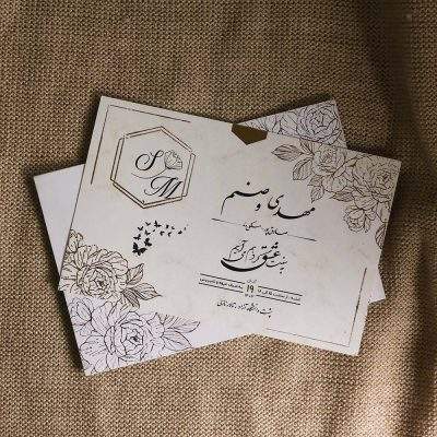 کارت عروسی مدل IL1167 با طراحی مینیمال و برش چند ضلعی روی پاکت، جلوه‌ای متفاوت و مدرن دارد. مقوای خارجی با کیفیت، لیبل تزئینی و حلقه طلایی همراه کارت، آن را به انتخابی شیک و اقتصادی برای مراسم شما تبدیل می‌کند.