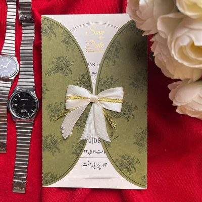 کارت عروسی مدل 1307 با پاکت سبز رنگ و برش حلالی، چاپ طرح گل روی پاکت، تزئین شده با ربان پاپیونی و طراحی داخلی اختصاصی عروس و داماد به همراه طلاکوب Save the Date انگلیسی.